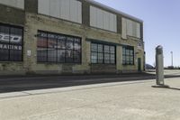 a motorcycle shop along a street with a sign attached to the side wall next to it