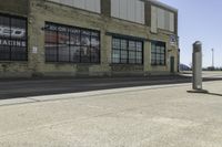 a motorcycle shop along a street with a sign attached to the side wall next to it