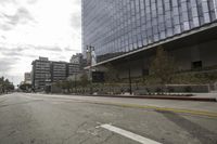a street with an empty road surrounded by high rise building on the other side of the building