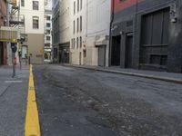an empty street that has a parking meter on it near some buildings in front of the building
