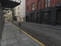 an empty street that has a parking meter on it near some buildings in front of the building