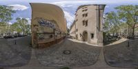 two large circular mirrors showing a street scene and buildings at the end of one photo