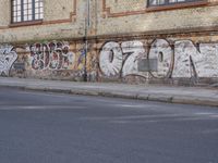 an image of a street scene with two motorcycles and some graffiti on the wall near the street