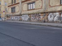 an image of a street scene with two motorcycles and some graffiti on the wall near the street