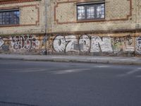 an image of a street scene with two motorcycles and some graffiti on the wall near the street