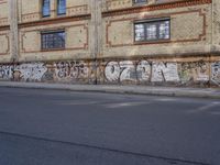 an image of a street scene with two motorcycles and some graffiti on the wall near the street