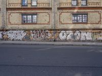 an image of a street scene with two motorcycles and some graffiti on the wall near the street