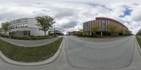 a view of a street through the two fisheyes of two street images of a building and a parking lot