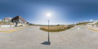 a fisheye image of a street view in an intersection with benches and stairs in the distance