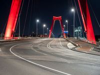 the highway crosses the large bridge at night time with cars driving under it and street lights