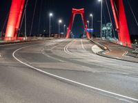 the highway crosses the large bridge at night time with cars driving under it and street lights