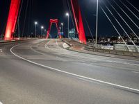 the highway crosses the large bridge at night time with cars driving under it and street lights