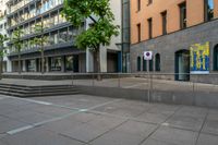 a very empty sidewalk and some very nice buildings with the stairs out front of it