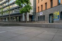 a very empty sidewalk and some very nice buildings with the stairs out front of it