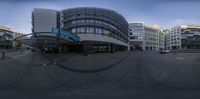 this is a round mirror that shows several buildings and some parking meters outside the building