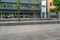 large stone steps are leading to a building with a glass enclosed entrance to the left