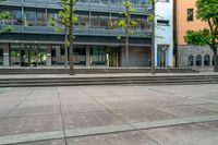 large stone steps are leading to a building with a glass enclosed entrance to the left