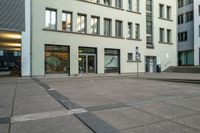 a building that has several windows next to a street sign and stairs to the first level