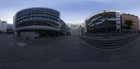 an 360 - fish eye view shows the view of the building on the left, and the large circular structure on the right