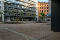 an empty street with two buildings in the background and some trees that have turned red