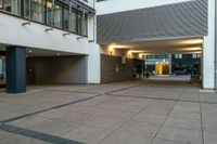 a picture of an empty public space by a building, and a sidewalk with a couple benches on the corner