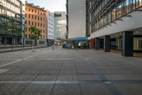 an empty city street with tall buildings around it and a crosswalk in the middle