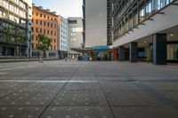 an empty city street with tall buildings around it and a crosswalk in the middle