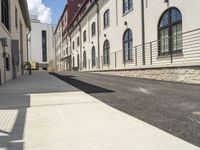 two buildings near a street that is empty and no people are walking on it or there