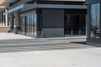 a person wearing a hat is walking outside of a business building that has glass doors and windows