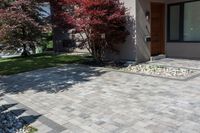 a brick patio with stone pavers in front of a home on an american country property