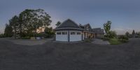 the view from behind of a driveway area at dusk, shows the garages and the driveway