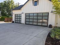 a two story building that has a black garage door with glass doors on the outside