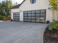 a two story building that has a black garage door with glass doors on the outside