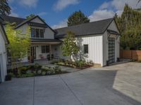 a home is outside with a patio area, yard and garage in front of it