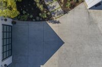 an aerial view of the courtyard area of a house, with some trees and shrubs