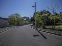 a narrow street with the sydney bridge in the background and trees along the side in front of it