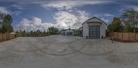 a home that is empty in the day light of day with a cloud over the large driveway