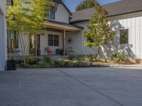 an empty driveway with trees in the front yard and a red sign with the word red on it