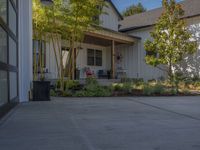 an empty driveway with trees in the front yard and a red sign with the word red on it