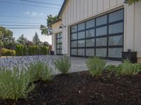 garage door with metal frame in front and bushes in the background with blue sky overhead