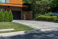 a driveway leading to a house with a concrete patio and lawn areas next to the entry