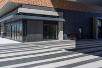 the building is full of glass windows and doors with bicycles parked along it's side