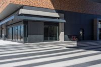 the building is full of glass windows and doors with bicycles parked along it's side