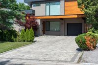 a modern style home with wood and glass windows on one of the sides of its driveway