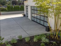 a house with white siding and a glass door with black handles and bamboo planters on each side