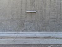 a man is standing with his arms spread in front of the wall and pointing at it