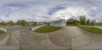 this fisheye photograph depicts two homes on a suburban lot in a neighborhood that appears to be an intersection