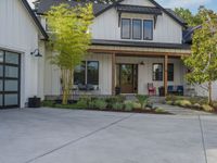 a home with two garage doors and a white sidinged exterior has a green front yard with a red fire hydrant, and a black railing