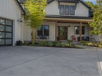 a home with two garage doors and a white sidinged exterior has a green front yard with a red fire hydrant, and a black railing