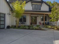 a home with two garage doors and a white sidinged exterior has a green front yard with a red fire hydrant, and a black railing